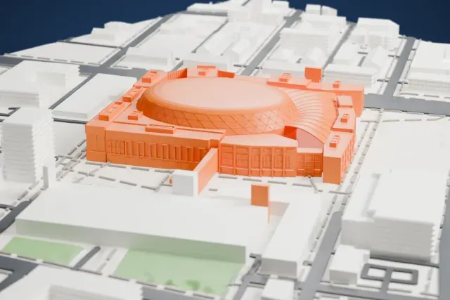 A white 3D print of Little Caesars Arena, a domed arena with a diamond-lattice band around its roof, surrounded by low buildings, streets and open lots.