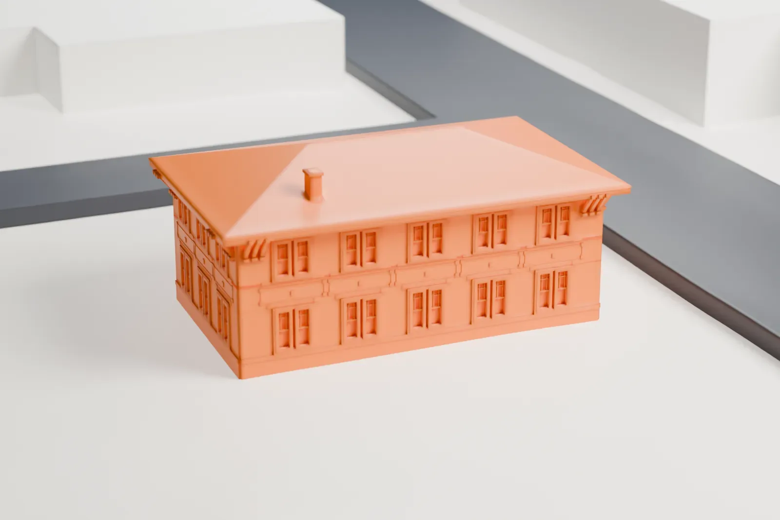 A white 3D print of the Little Falls Municipal Building, a two-story building with a hipped roof and a small entry porch, beside a street and open ground.
