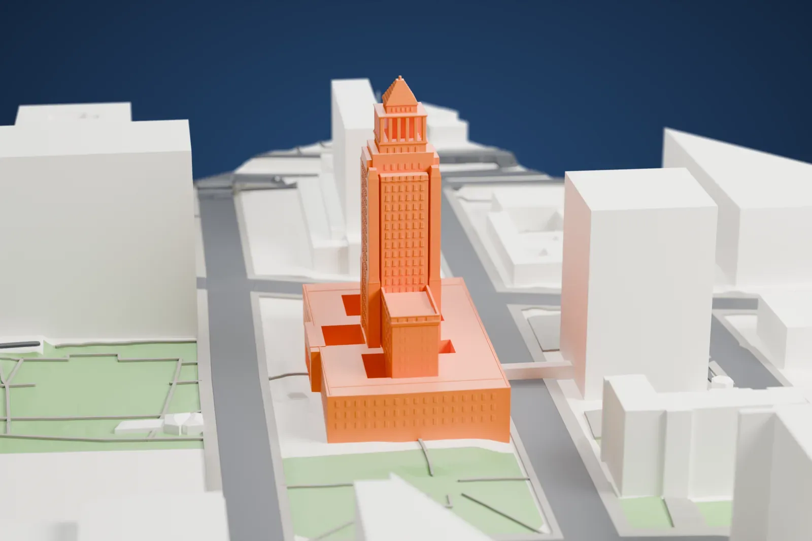 A white 3D print of Los Angeles City Hall, a tall building on its city block among the surrounding streets and buildings of downtown.