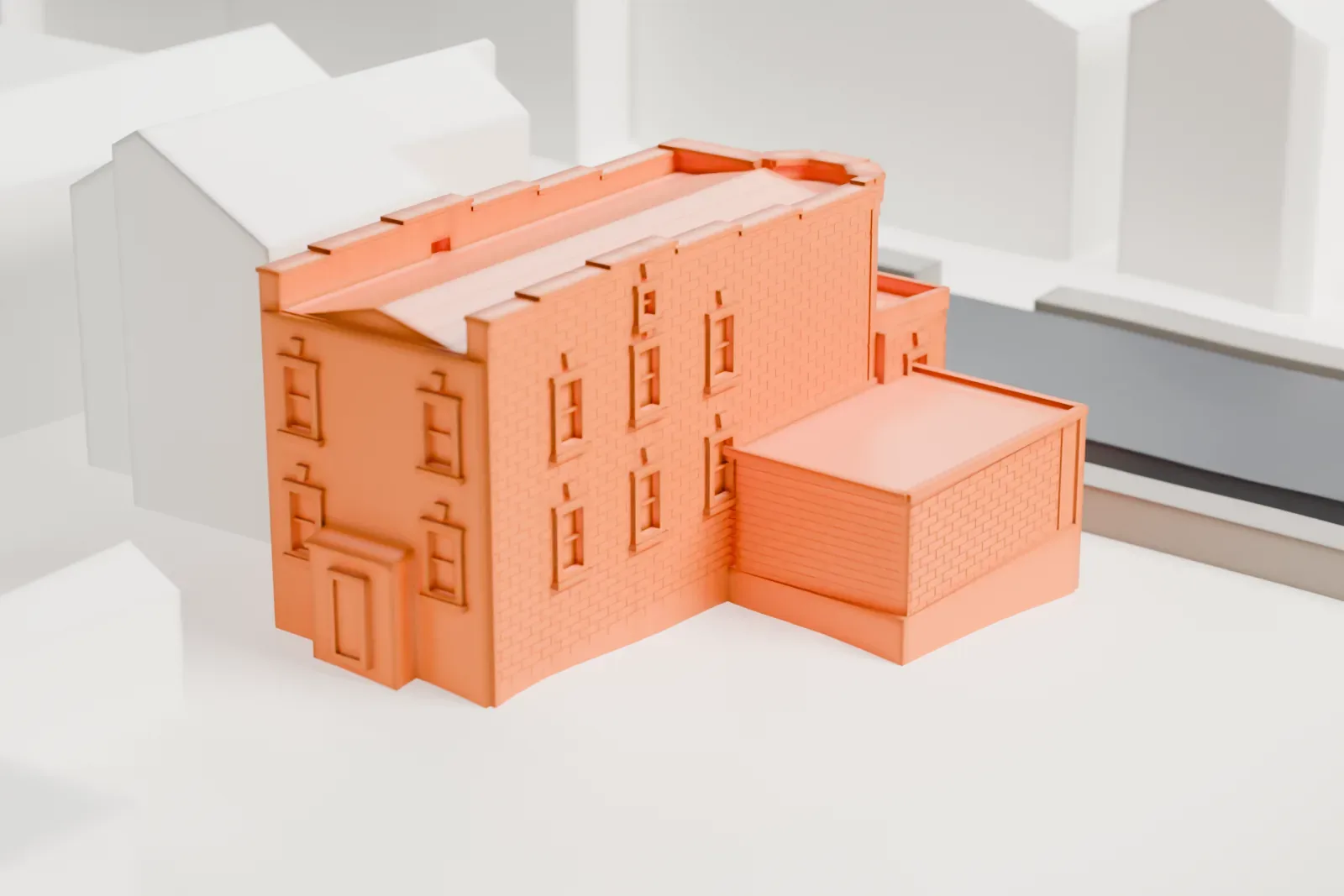 A white 3D print of the Louis Armstrong House, a small brick house with a sloped roof and a low side addition, beside a street and neighboring houses.