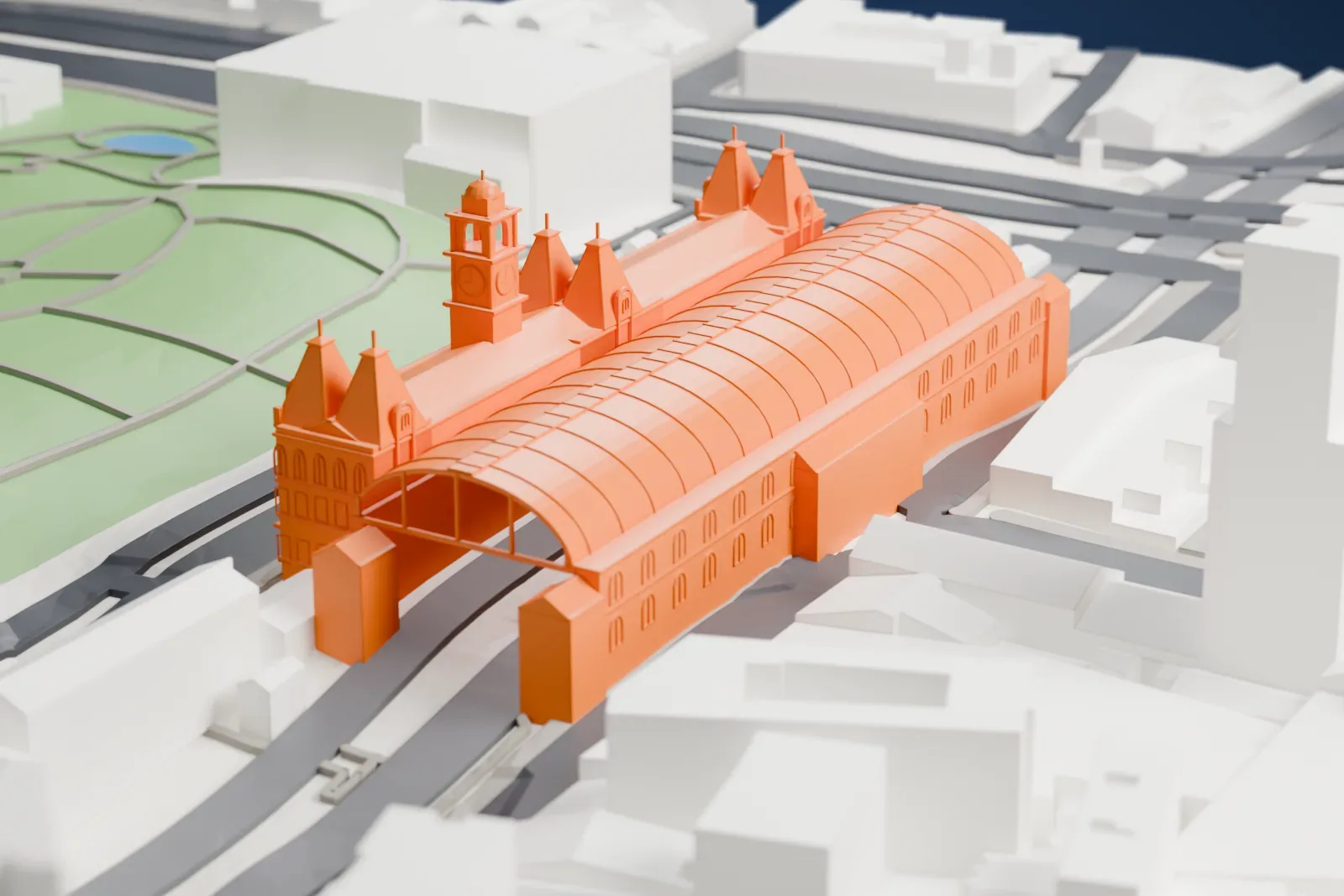 A white 3D print of Luz Station, a large railway station building among the surrounding city blocks.