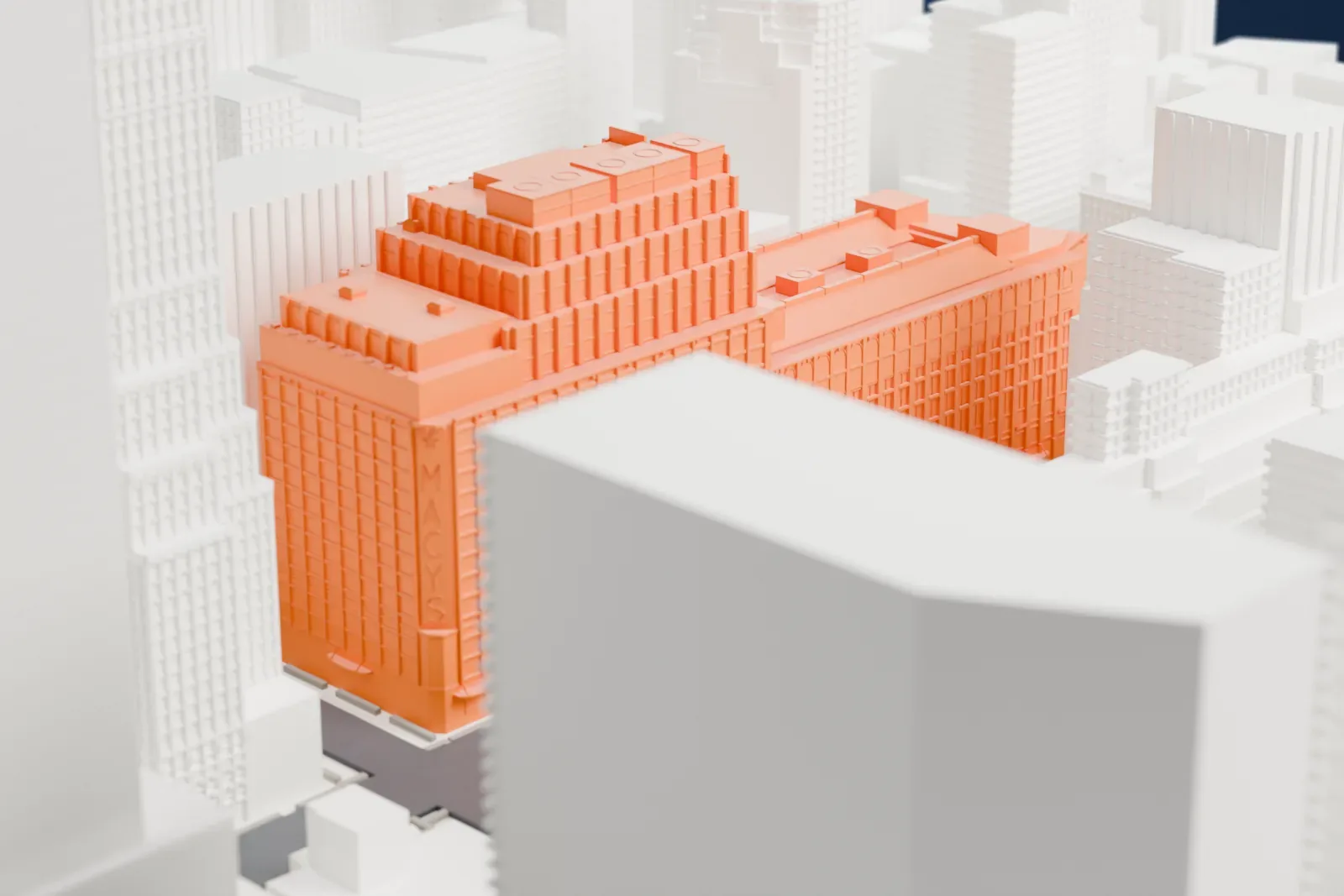 A white 3D print of the Macy's Herald Square store, a large stepped block with a taller tower section, surrounded by Midtown buildings and streets.