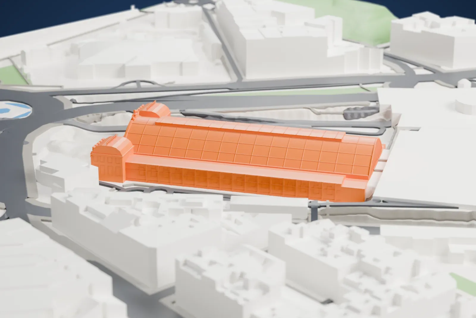 A white 3D print of Madrid Atocha, a long station with a high roof, among the surrounding streets and buildings of Madrid.