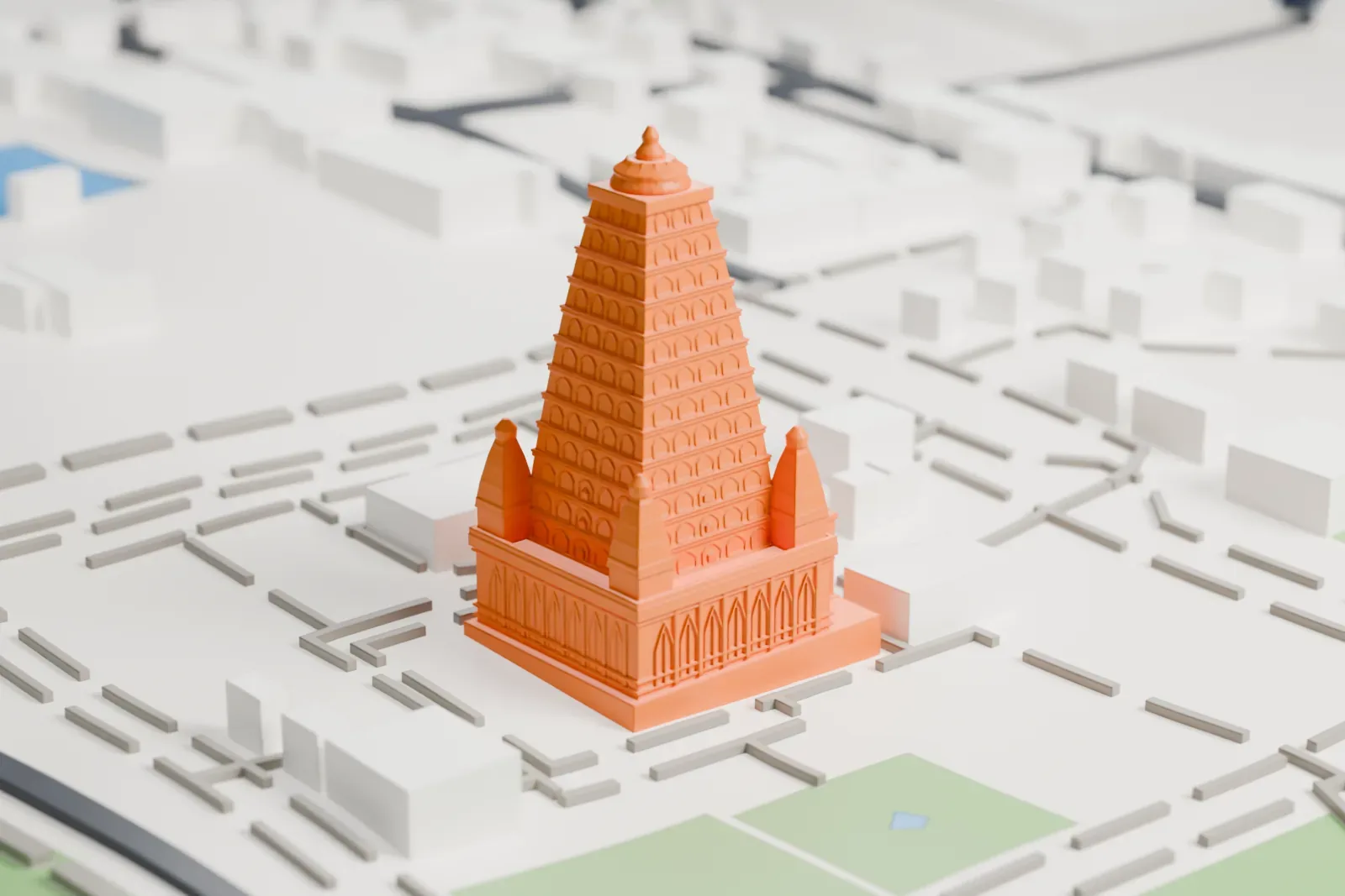 A white 3D print of the Mahabodhi Temple, a tall stepped tower covered in rows of small arched niches with four small towers at its base, set among low buildings, paths and a rectangular pool of water.