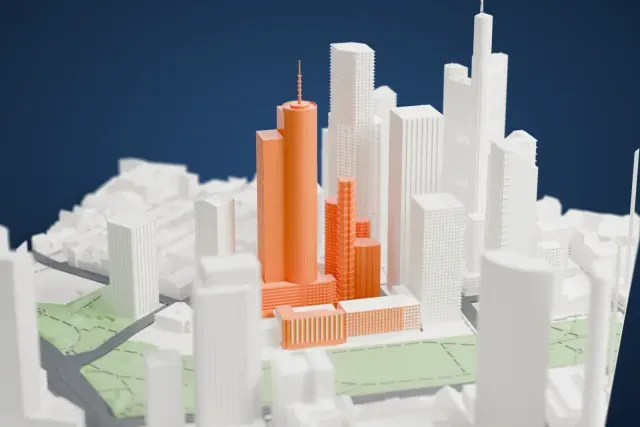 A white 3D print of Main Tower, a slim skyscraper with a round tower, a boxy section and a thin antenna on top, standing among other Frankfurt towers beside a green park.