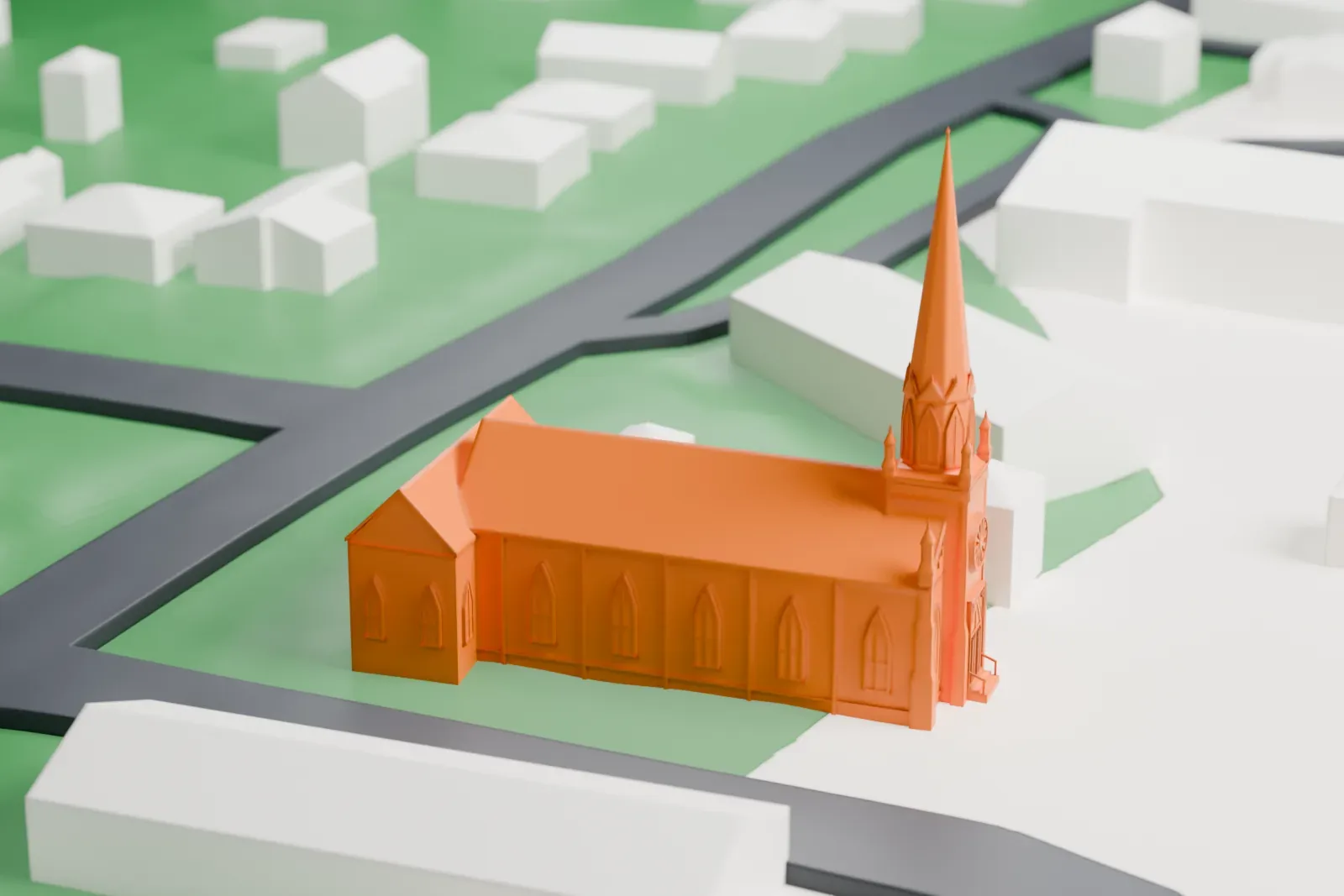 A white 3D print of Mamaroneck Methodist Church, a long gabled church with a tall spire at one end, on a green lot among small buildings.