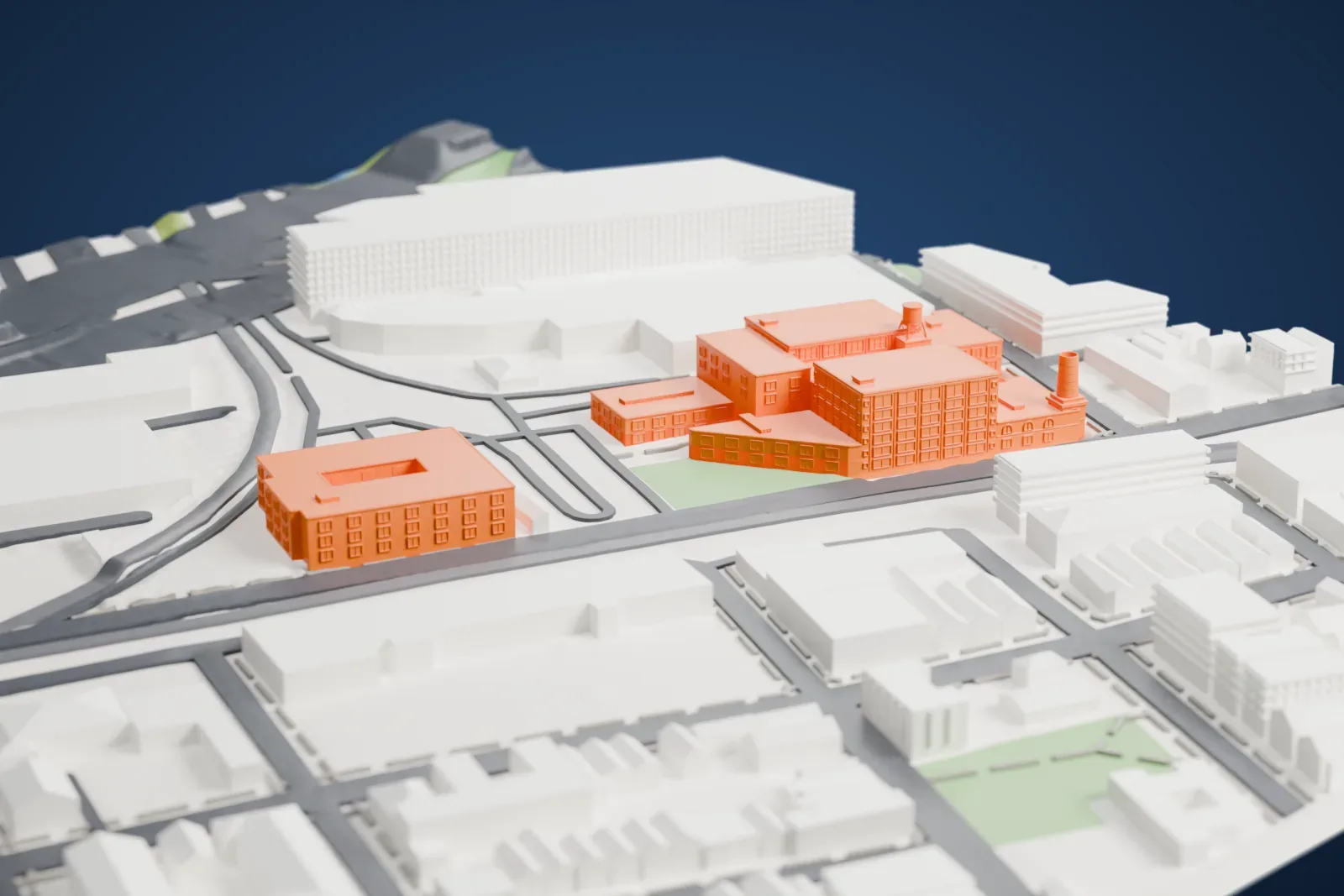A white 3D print of Mana Contemporary, a cluster of large factory-style buildings with a chimney stack and a water tower, beside wide roads and a second courtyard building.