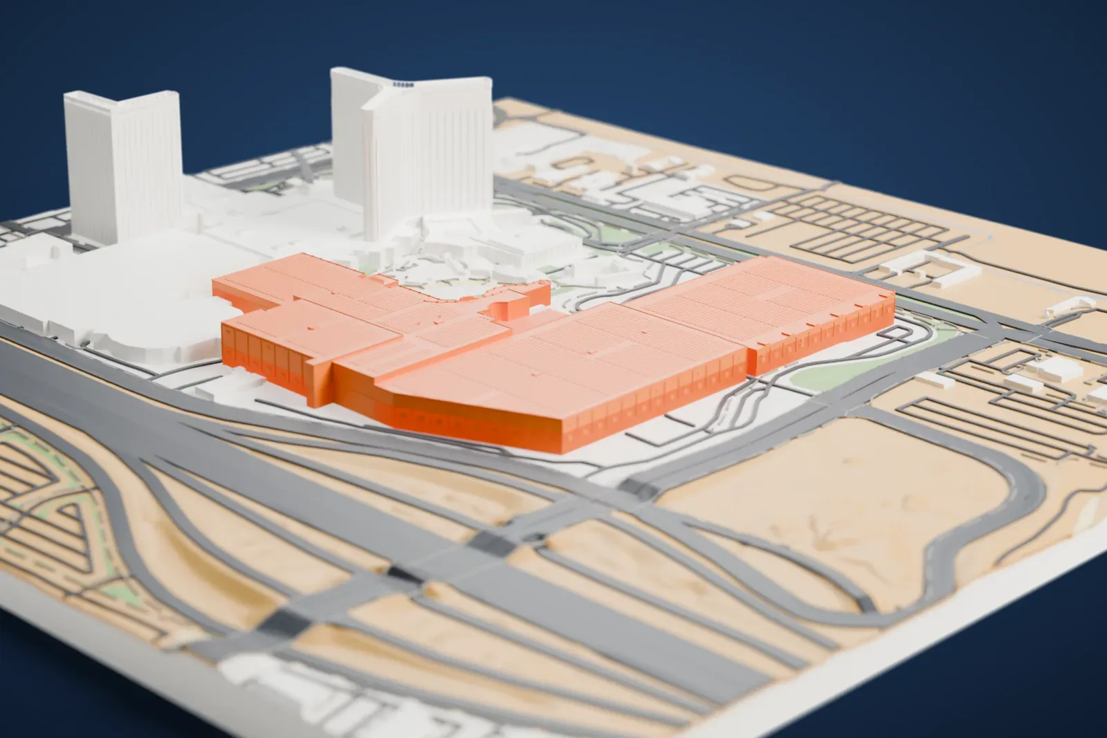 A white 3D print of Mandalay Bay Convention Center, a cluster of wide, low halls with finely banded roofs, beside a curved-wing tower and wide roads.