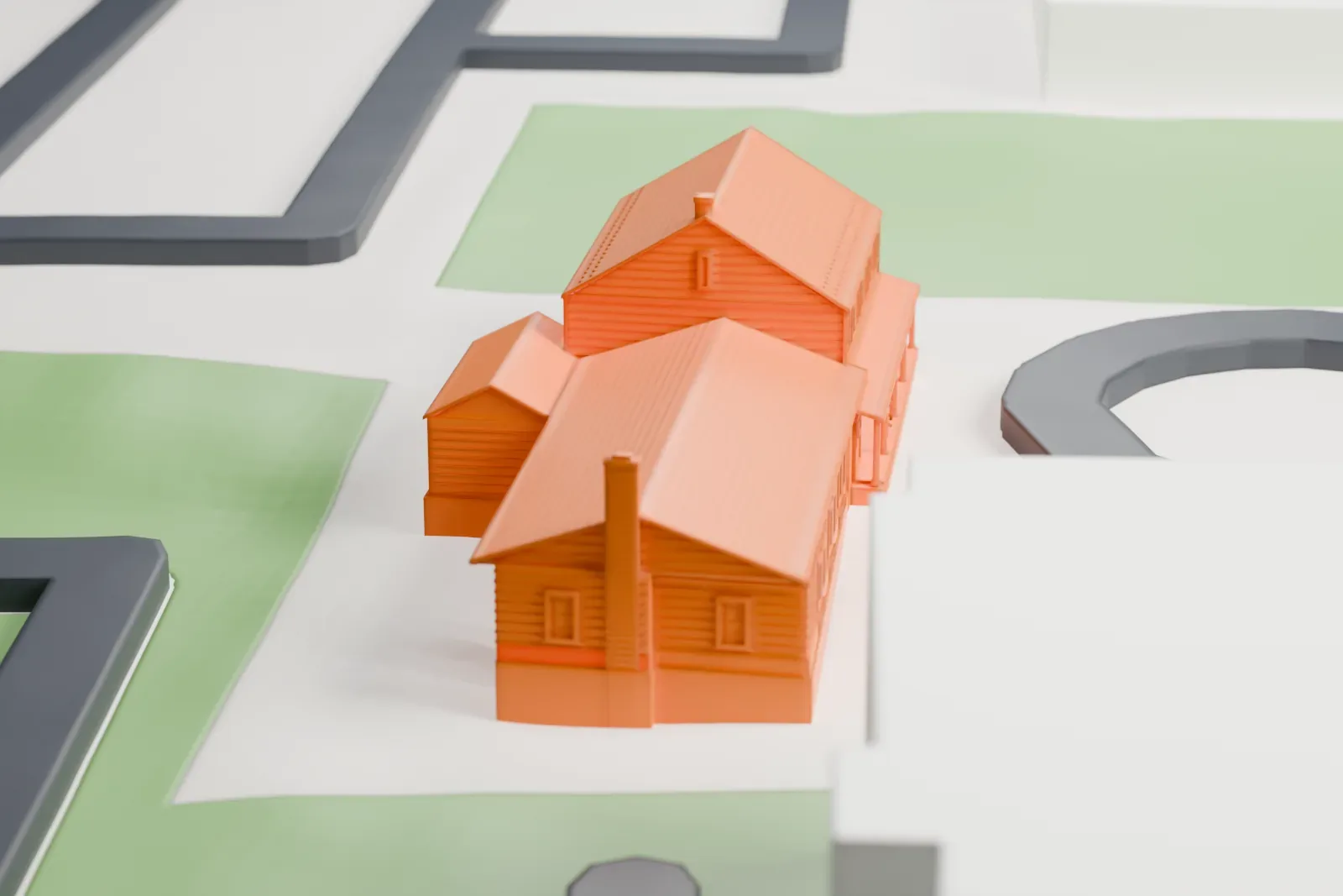 A white 3D print of the Manhasset Quaker meeting house, a long building made of gabled sections with a front porch, on a lawn beside a looping driveway.