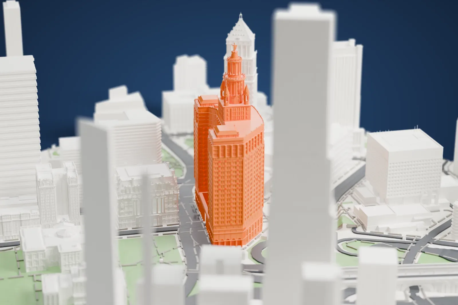 A white 3D print of the Manhattan Municipal Building, a wide tower with a tiered crown and small spires, beside roads, small parks and taller buildings.