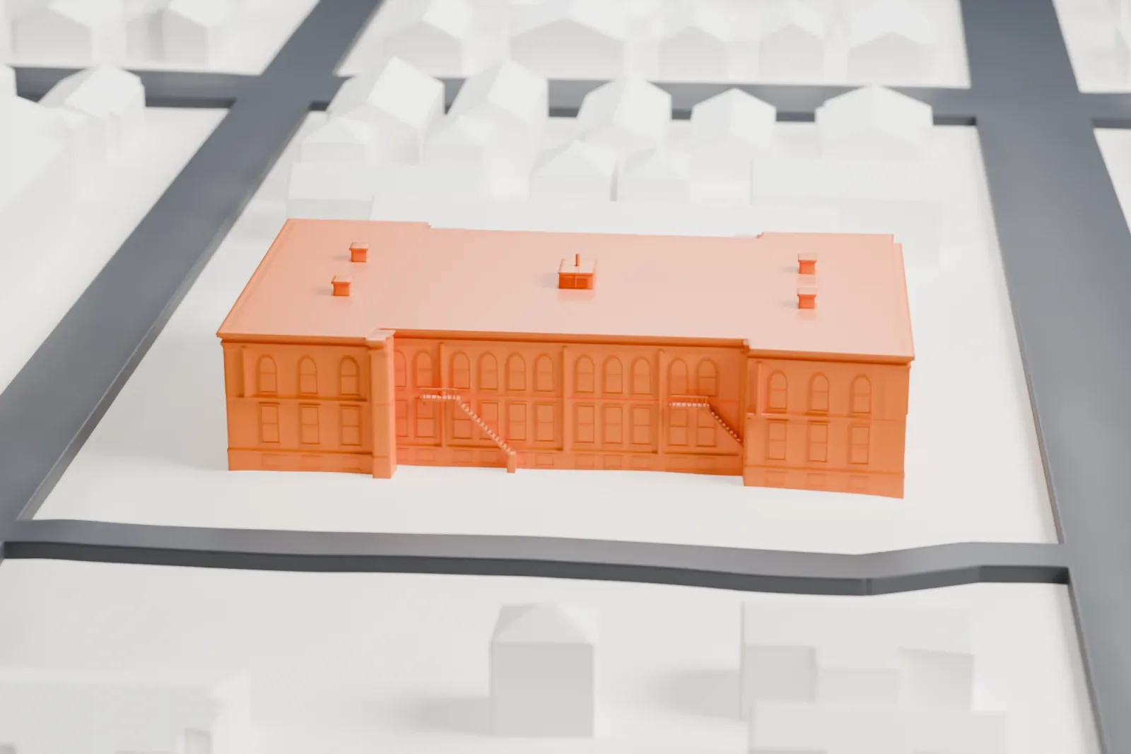 A white 3D print of the Maplewood School, a large two-story building with a flat roof and arched windows, on its block among small houses and streets.