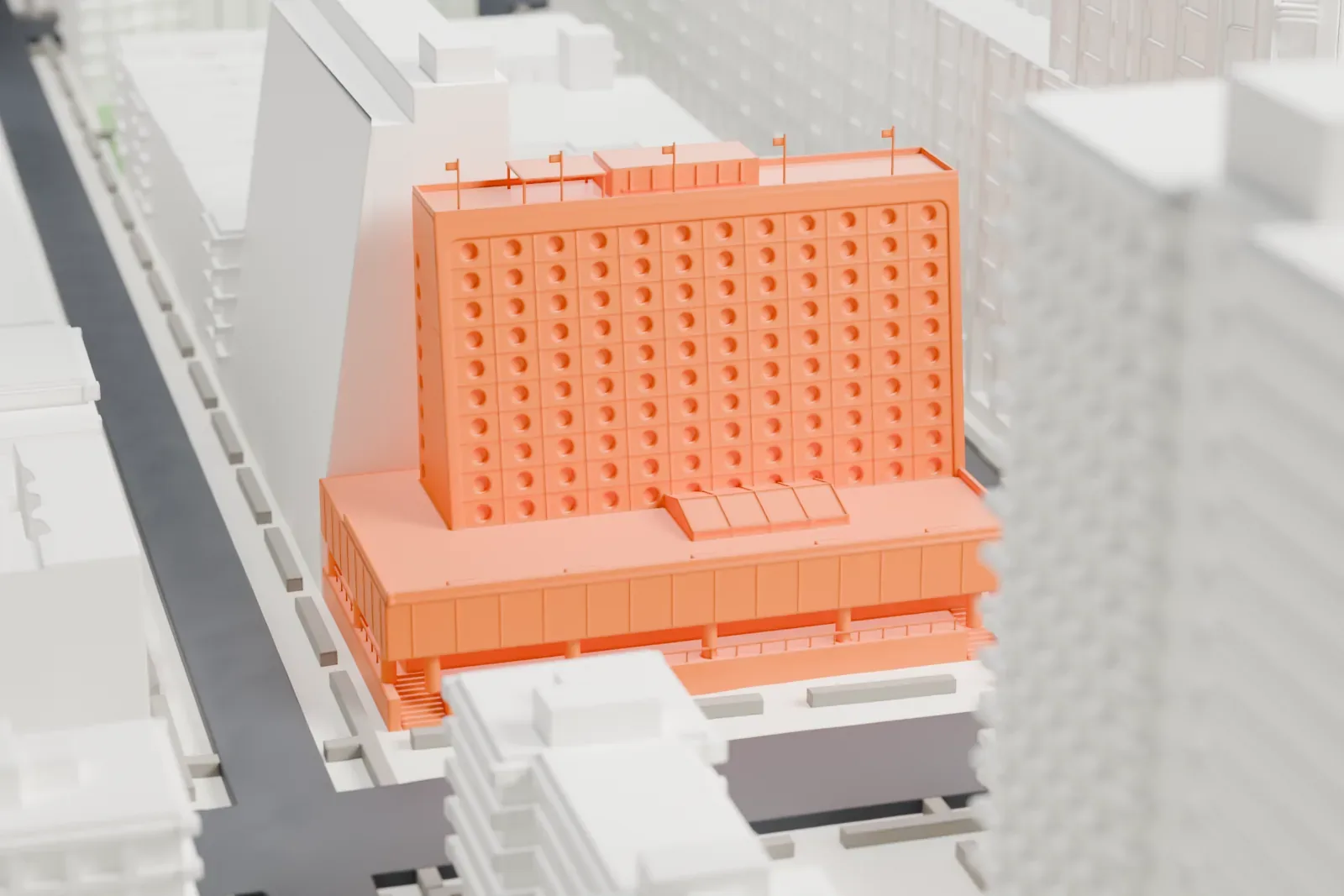 A white 3D print of the Maritime Hotel, a slab with a sloping porthole-studded facade above a wide low base, set among taller and shorter buildings on narrow streets.