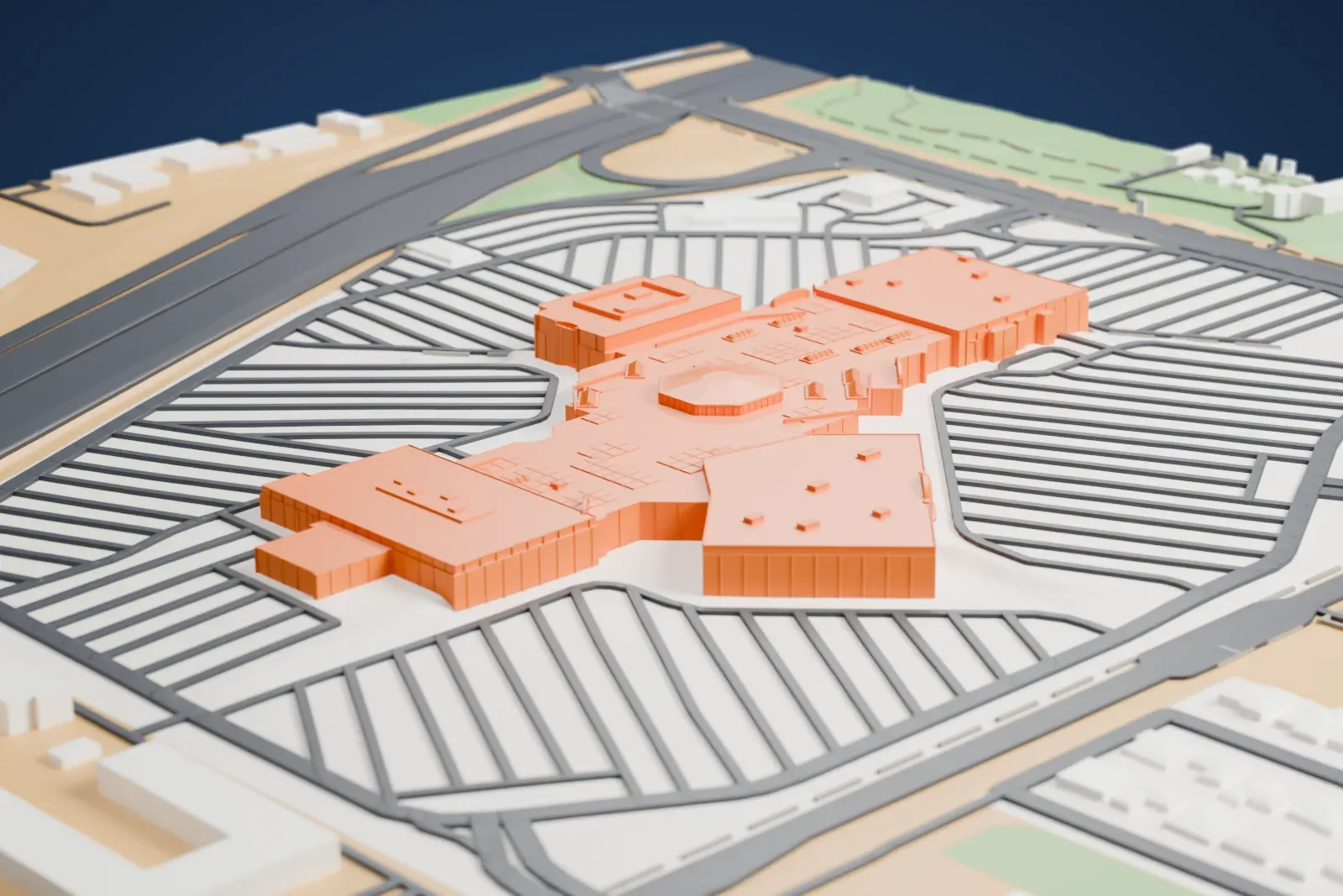 A white 3D print of Meadows Mall, a low sprawling mall with several wings, surrounded by large striped parking areas and a highway.
