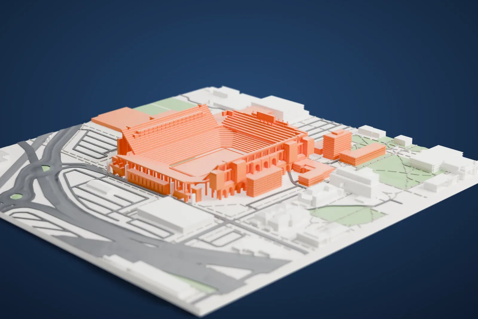 A white 3D print of Memorial Stadium, a stadium of stepped seating tiers with a row of arches at one end, set among campus buildings, parking and wide roads.