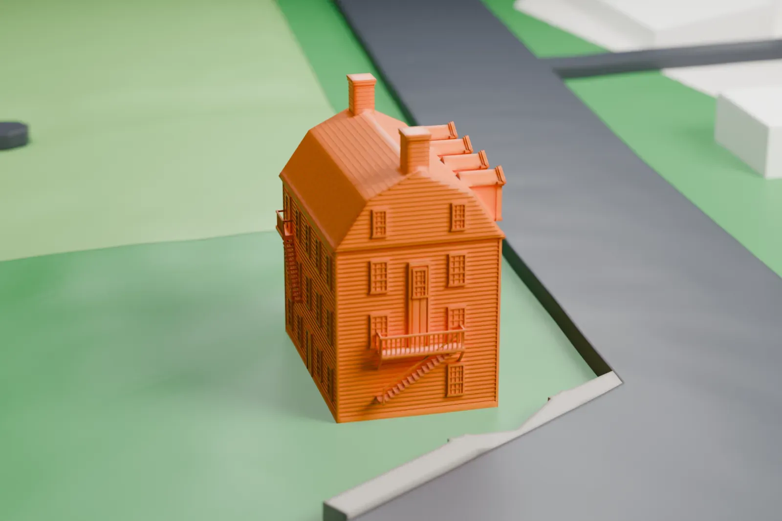 A white 3D print of the Merchants and Drovers Tavern, a tall building with a steep roof, a row of dormers and chimneys, standing on grass beside roads.