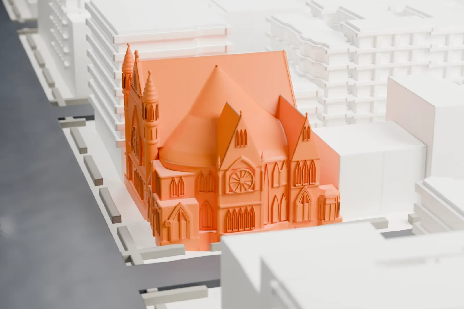 A white 3D print of the Metropolitan Baptist Church, a church with steep pointed roofs, small towers and a gabled front with round and arched windows, among lower buildings and streets.
