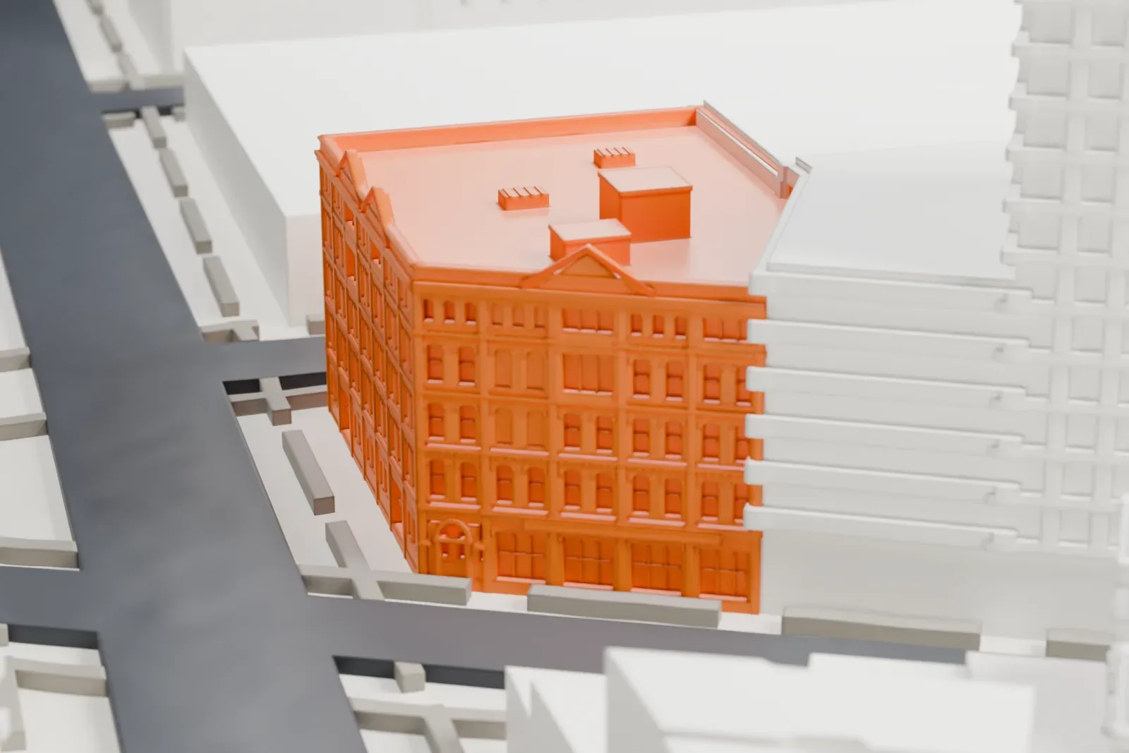 A white 3D print of the Mink Building, a large corner building with small gables along its roofline, standing among taller buildings.