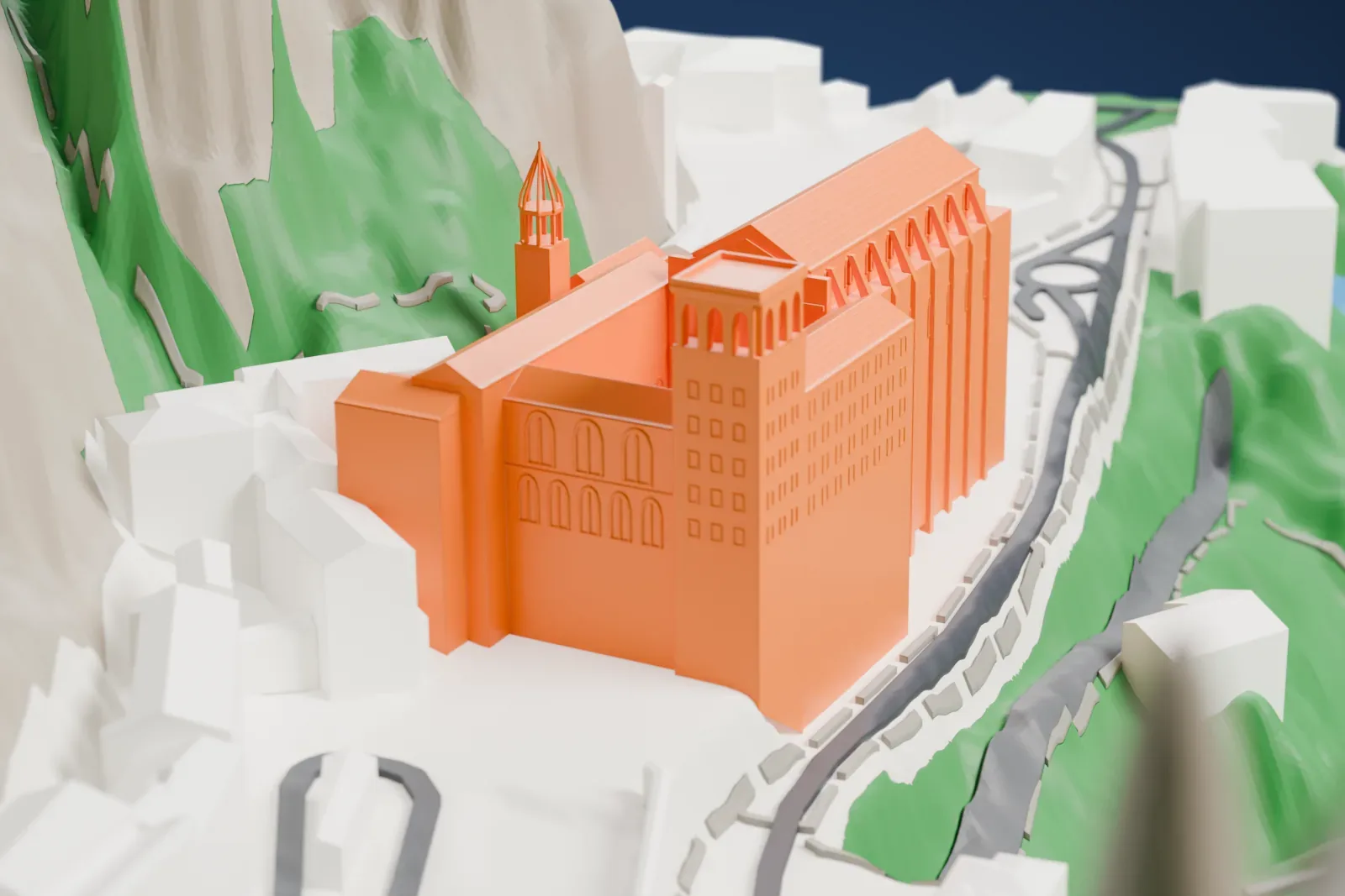 A white 3D print of the Montserrat Monastery with ridged roofs and towers beside steep rocky slopes, a winding road, and neighboring buildings.