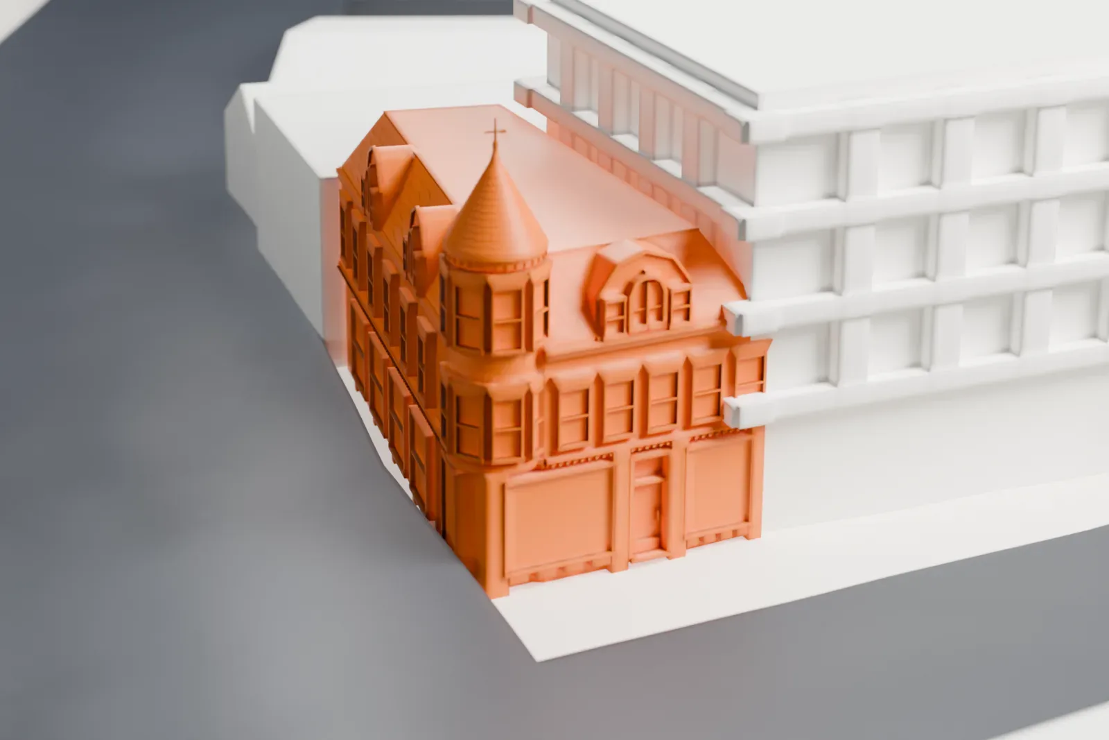 A white 3D print of Moore's Building, a corner building with a round turret, dormers and a steep patterned roof, beside streets and larger buildings.