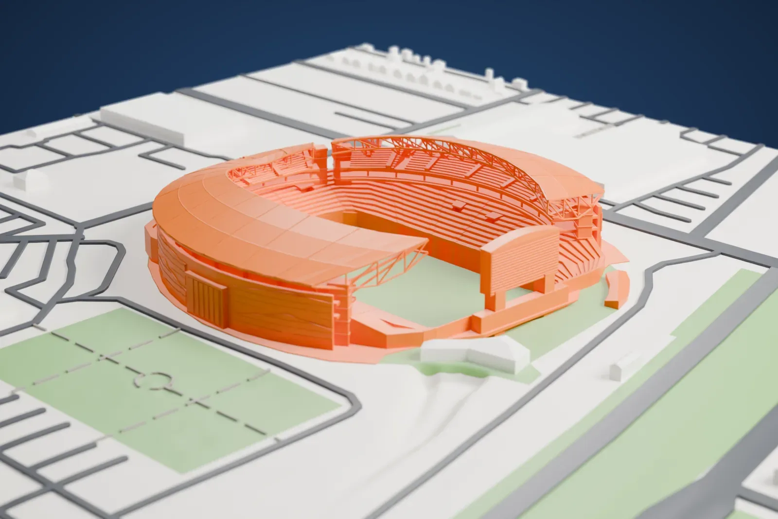 A white 3D print of Mosaic Stadium, an oval bowl with a curved roof over most of its rim and one open end, surrounded by roads and green sports fields.