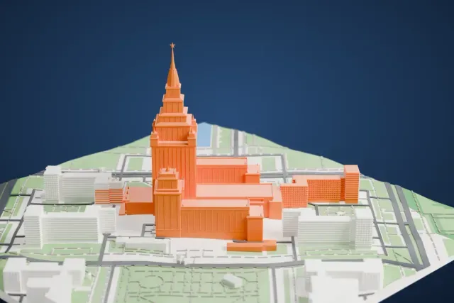 A white 3D print of Moscow State University's main building, a stepped central tower with a spire and corner towers, surrounded by streets, park areas and other buildings.