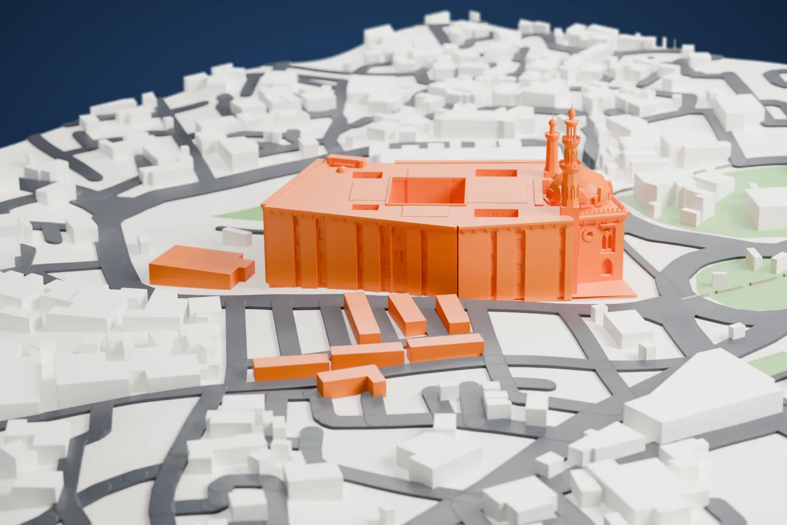 A white 3D print of the Mosque-Madrasa of Sultan Hasan, a large block with a dome and two slim minarets, among curving roads, a green traffic circle and low buildings.