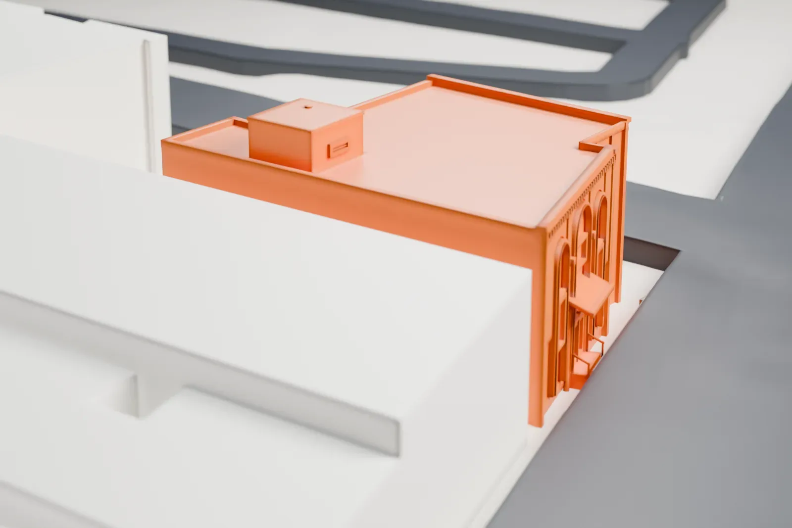 A white 3D print of Mosque No. 25, a small flat-roofed corner building with arched windows on its front, beside streets and larger plain buildings.