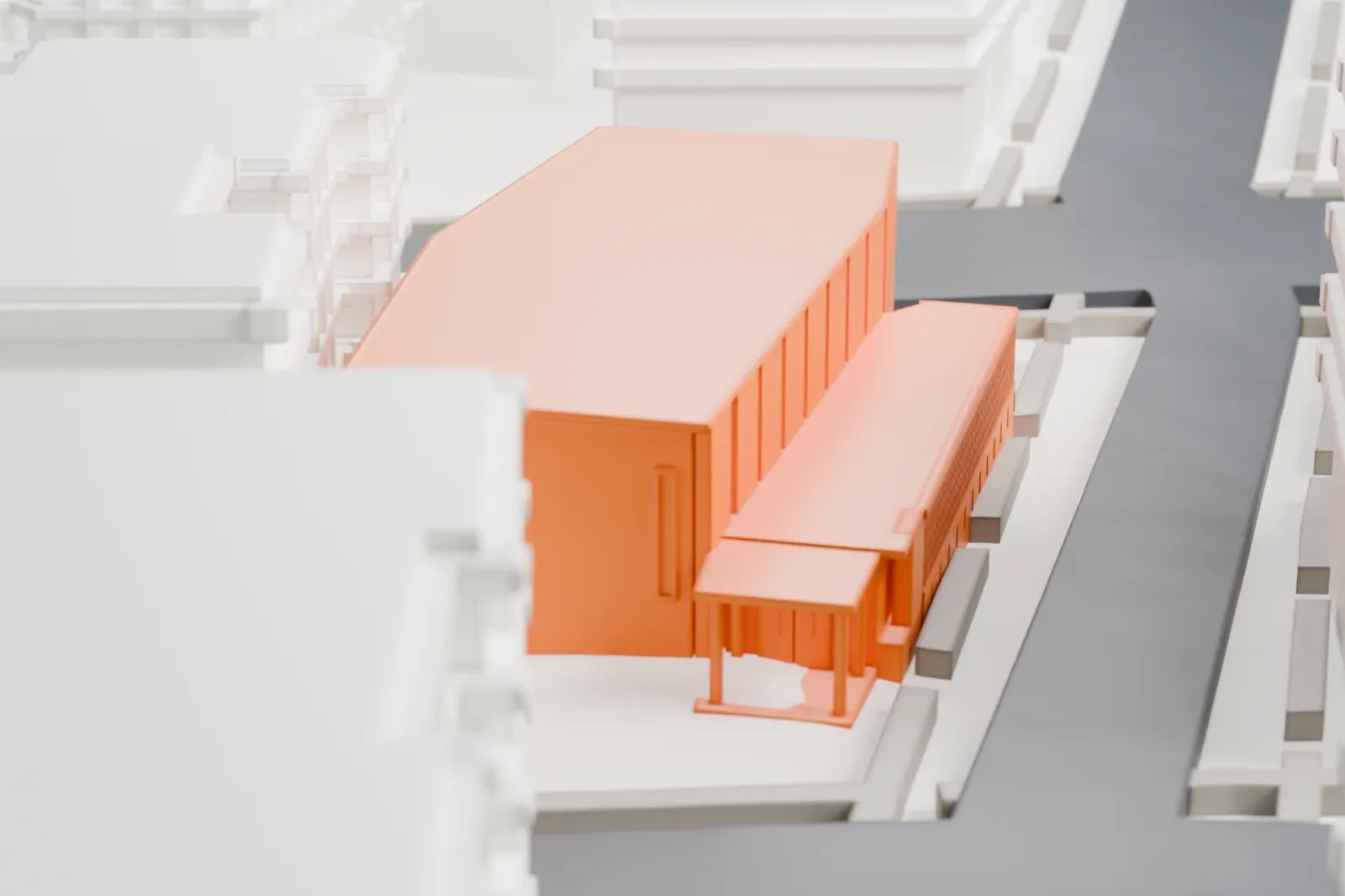 A white 3D print of the Mount Sinai Jewish Center, a wide low building with a sloping roofline, among mid-rise buildings and streets.