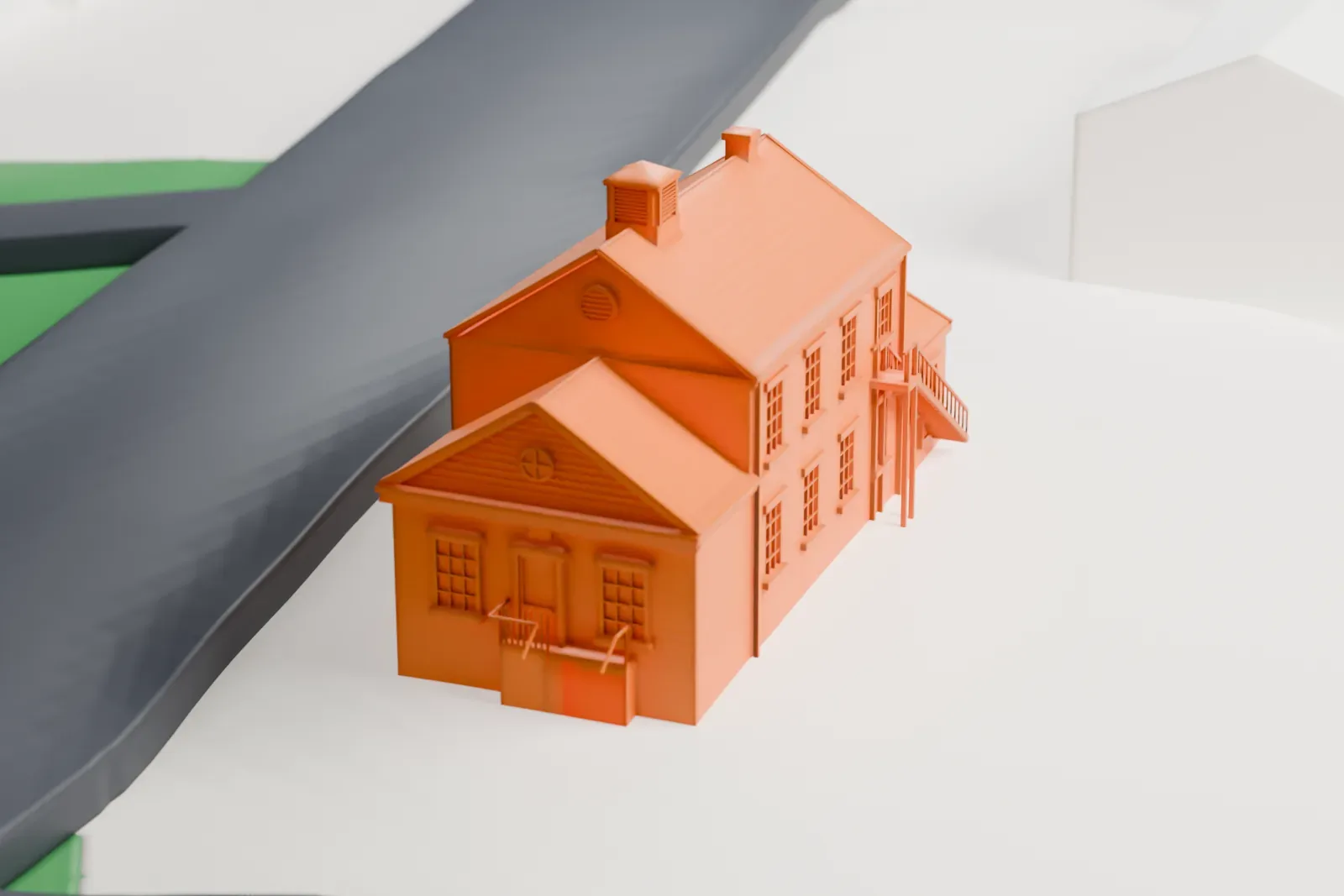 A white 3D print of the Mount Vernon School, a two-story brick schoolhouse with a chimney and side wings, beside curving roads and green lawn.