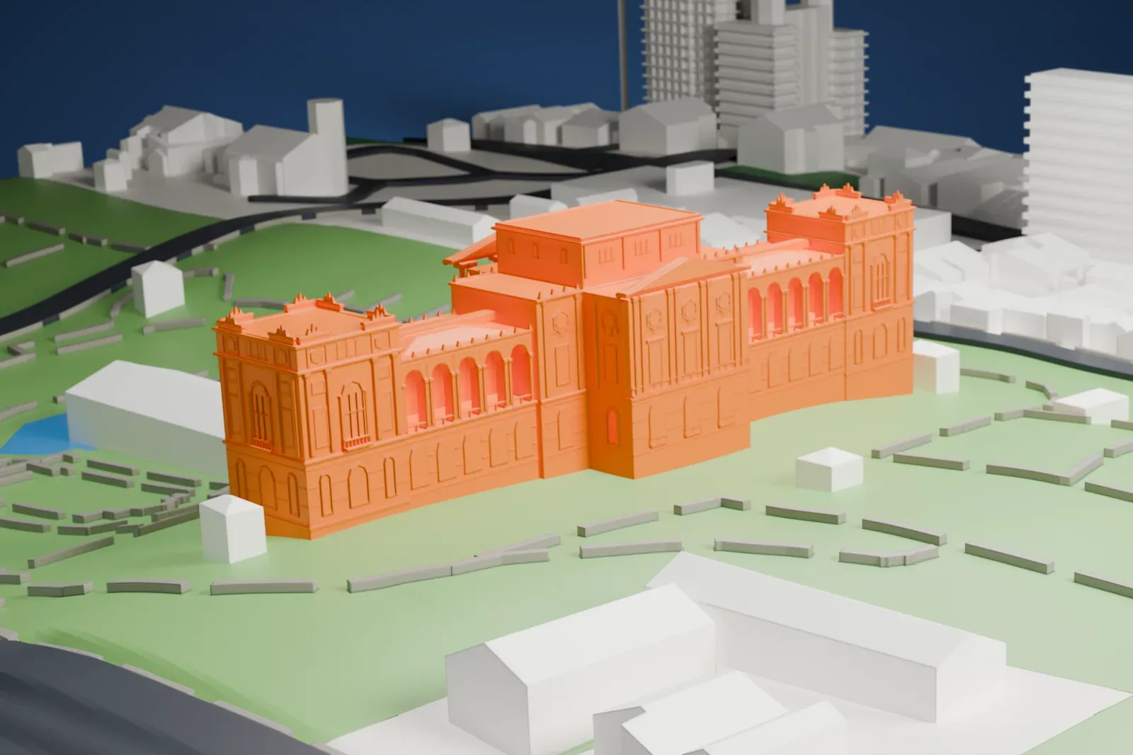 A white 3D print of the Museu Paulista, a long palace with a central block and end towers, standing in a green garden with paths and ponds.