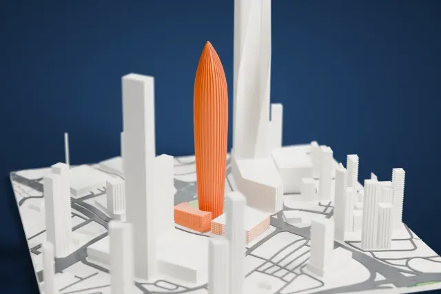 A white 3D print of the NBK Tower model in Kuwait City, with the streets around it.