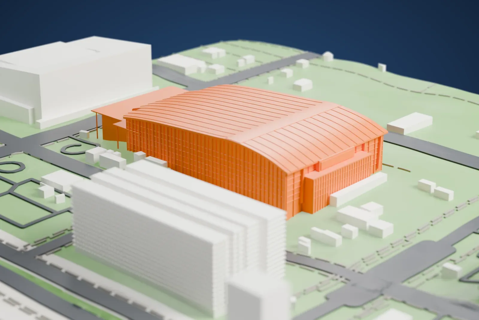 A white 3D print of the National Indoor Stadium, a glass hall under one long curved roof with a canopy along its side, among the streets and buildings around it.