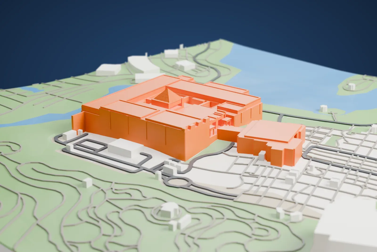 A white 3D print of the National Museum of Egyptian Civilization, beside Ain el-Sera Lake in Old Cairo, among the surrounding streets and buildings.