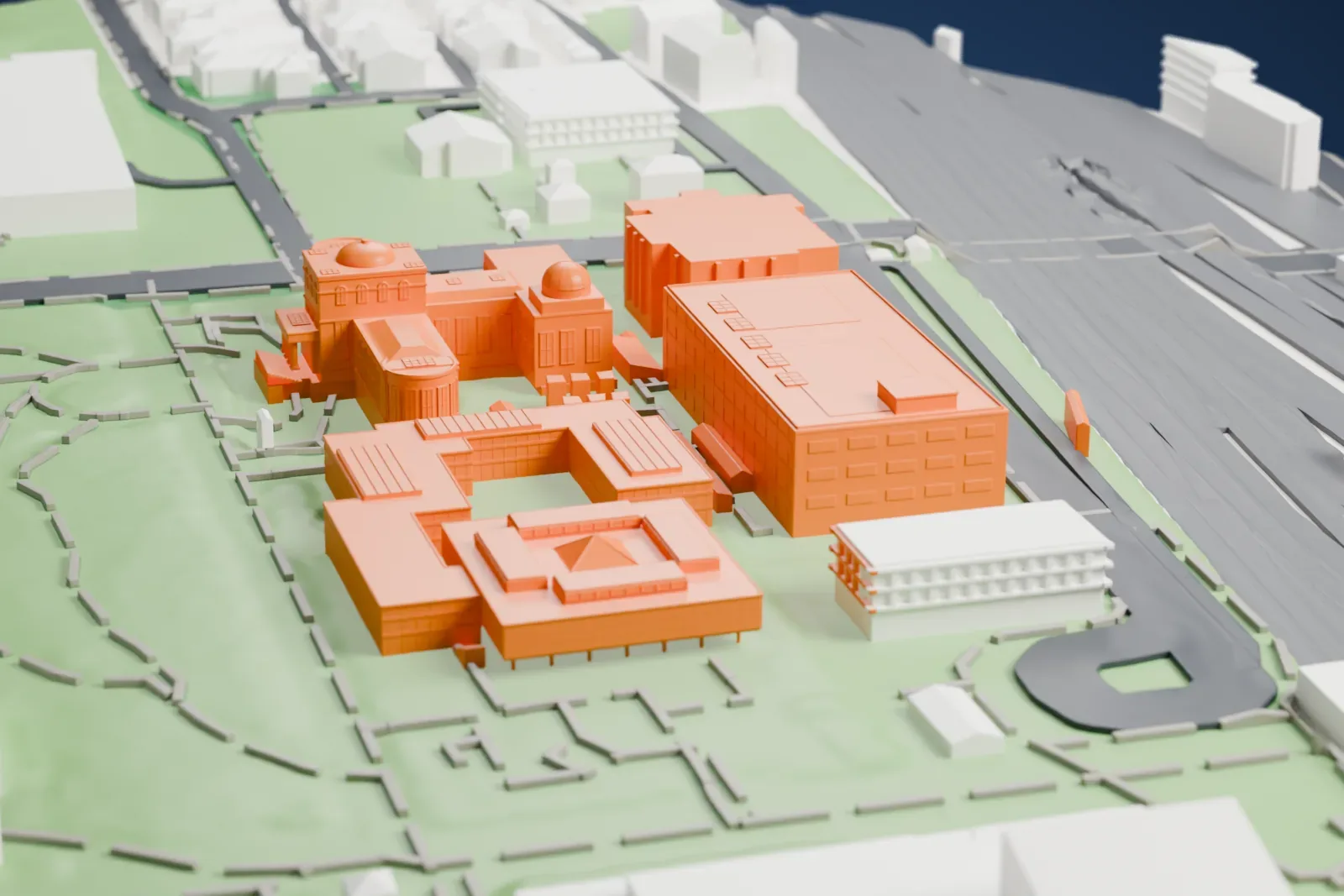 A white 3D print of the National Museum of Nature and Science, an older domed building beside a large block with rows of windows, set in green parkland.