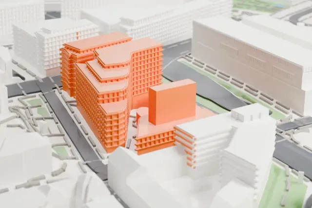 A white 3D print of the National Museum of Norway, a long, low building with stepped flat roofs beside the harbor, surrounded by streets and mid-rise buildings.