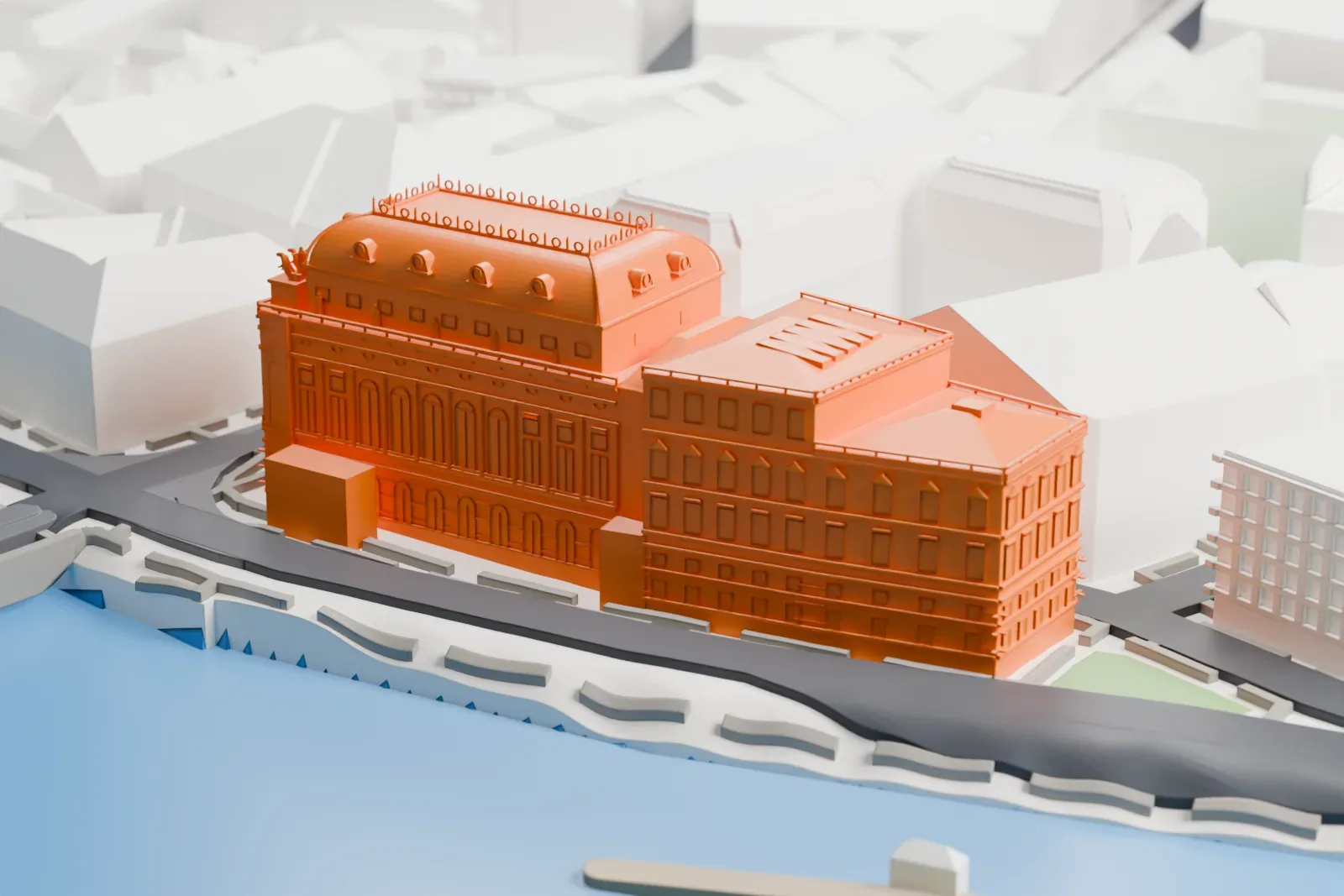 A white 3D print of the National Theatre, an ornate building with a curved roof and a lower wing, standing beside a river with dense buildings behind it.