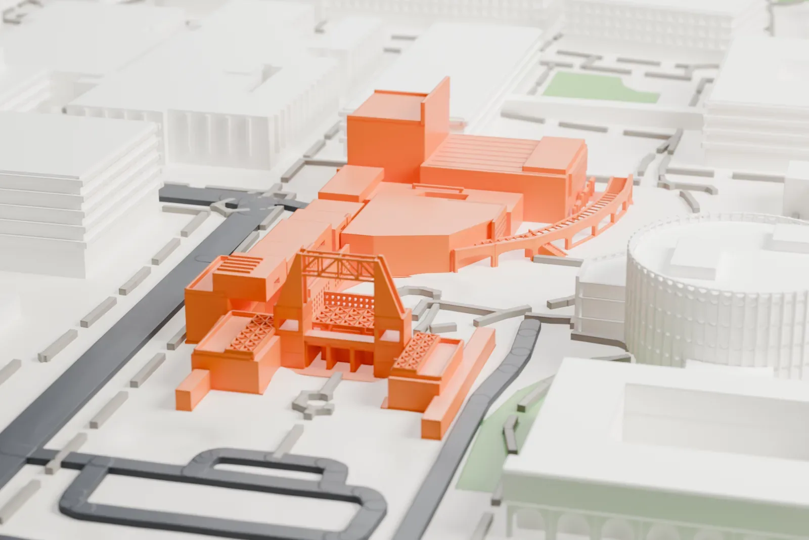 A white 3D print of the Nelson Fine Arts Center, a cluster of angular blocks with a curved ramp and an open lattice frame, among campus buildings and paths.