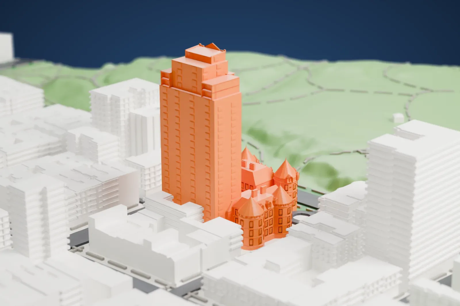 A white 3D print of the New York Cancer Hospital, a castle-like building with conical towers beside a tall tower, facing a hillside park with taller blocks around.