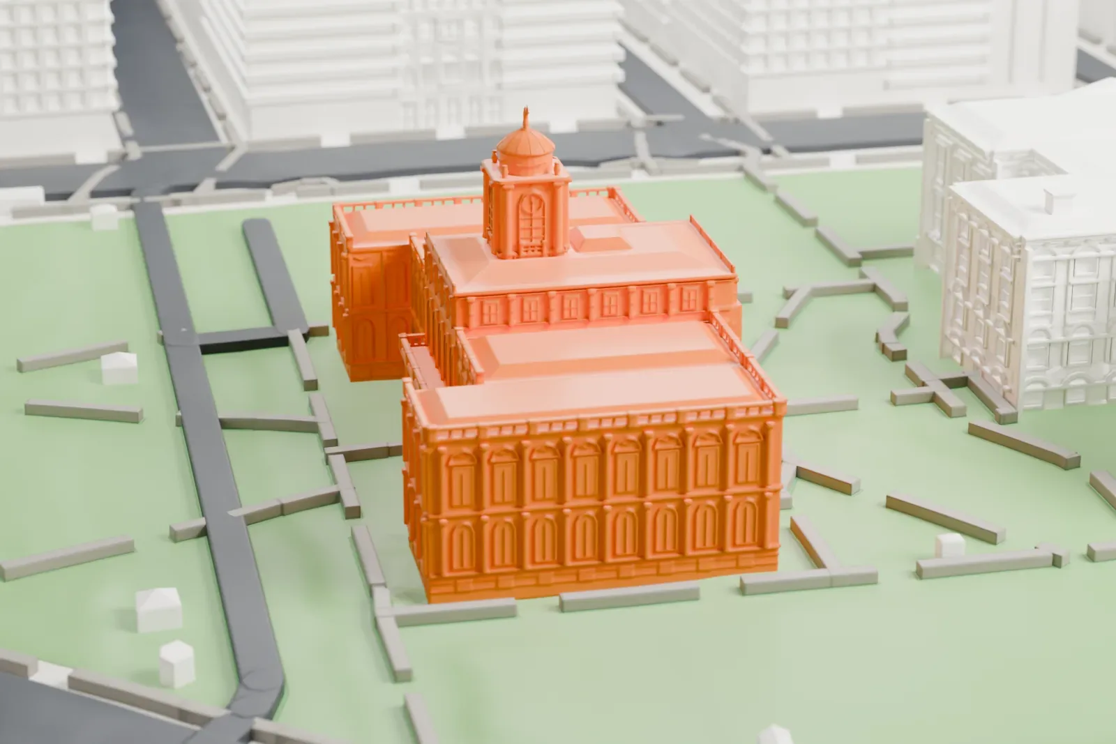 A white 3D print of New York City Hall, a wide building with a small domed tower, set in a park and ringed by taller buildings and streets.