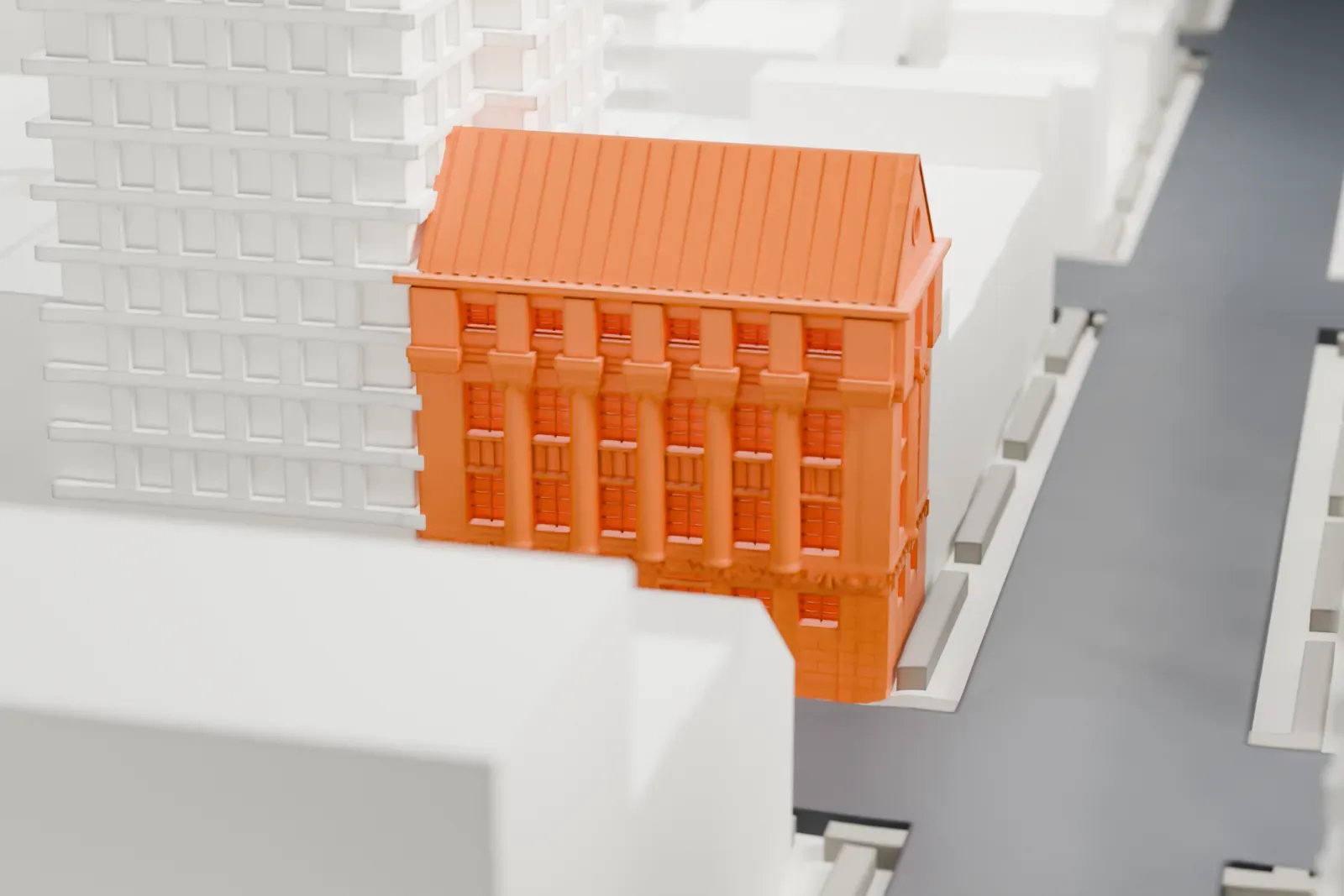 A white 3D print of the New York School of Applied Design building, a small building with a steep gabled roof, hemmed in by tall buildings on a dense city block.