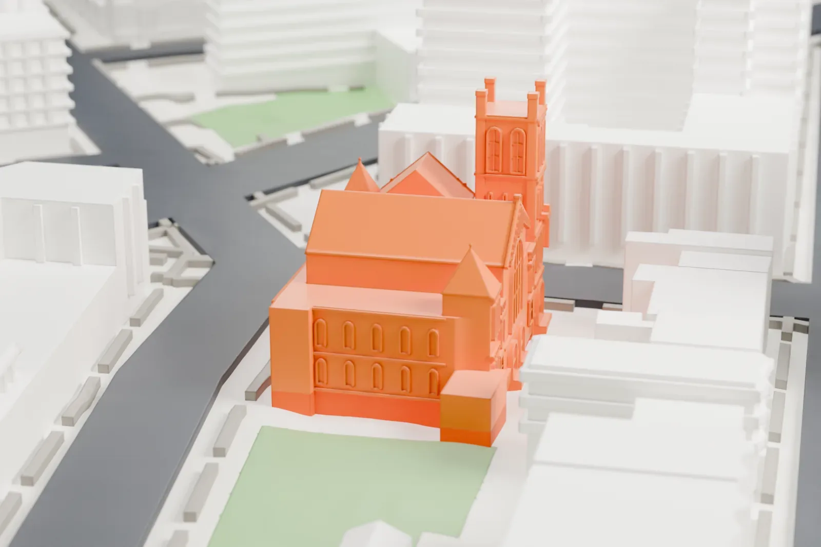 A white 3D print of Next Step Community Church, a large church with a tall corner tower and gabled roofs, standing among taller buildings and streets.