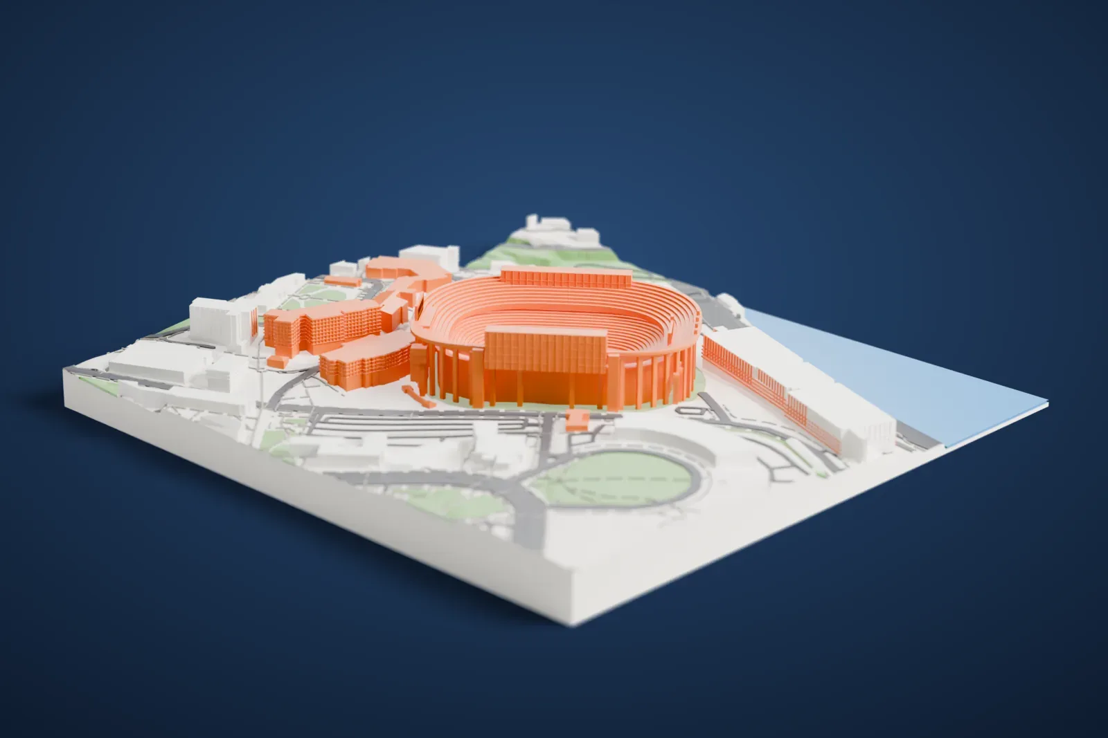 A white 3D print of Neyland Stadium, a large oval stadium with stepped seating rows and an arched outer wall, beside a stretch of water and surrounded by buildings, roads and green space.