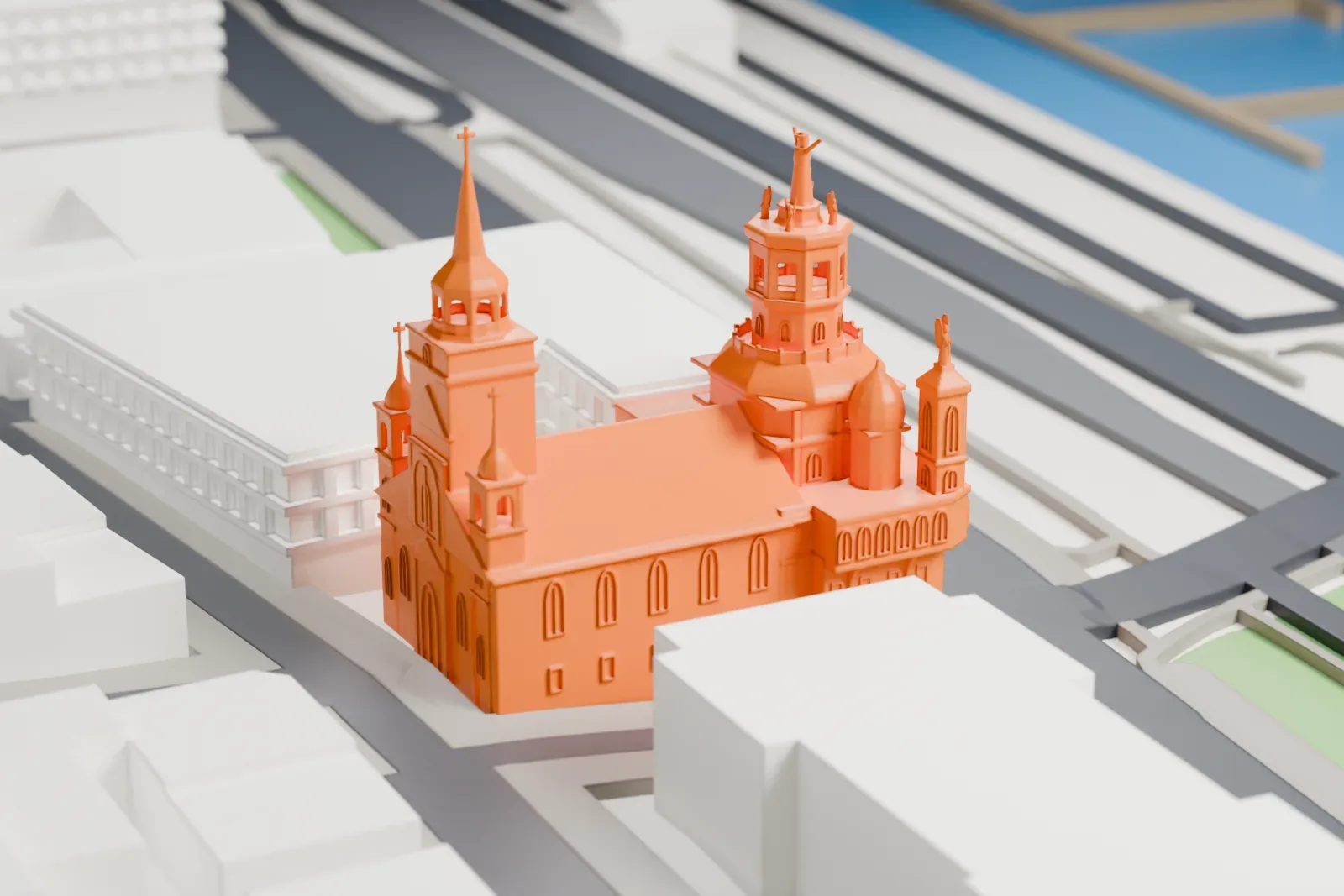 A white 3D print of the Notre-Dame-de-Bon-Secours Chapel, a small church with a spire, among the surrounding streets and buildings.