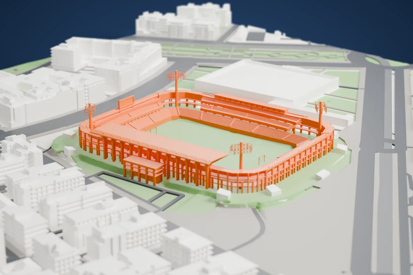 A white 3D print of the Nuevo Estadio de Los Cármenes, an open football bowl with four floodlight masts and a canopy over one stand, among the streets of the Zaidín district.