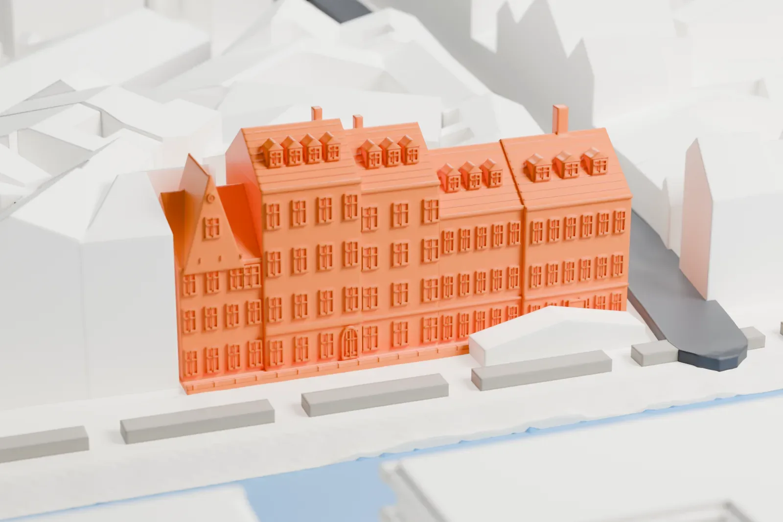 A white 3D print of a row of Nyhavn townhouses with steep roofs and dormers beside a canal, with other buildings and a quayside behind.