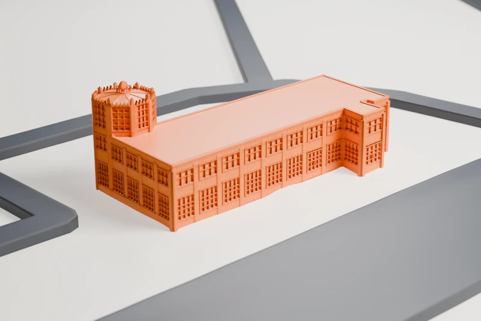 A white 3D print of the Old Port Columbus Terminal, a long, low building with rows of windows and a many-sided tower at one end topped by a toothed crown, on open ground between roads.