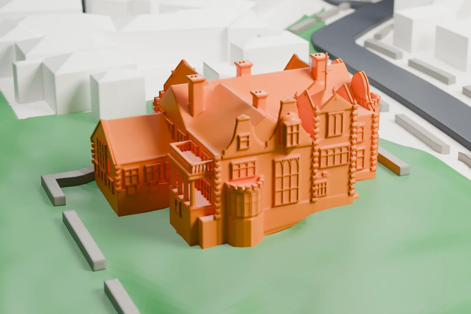 A white 3D print of the Olveston Historic Home with shaped gables, chimneys and a balcony, set among grounds, low walls, streets and neighboring buildings.