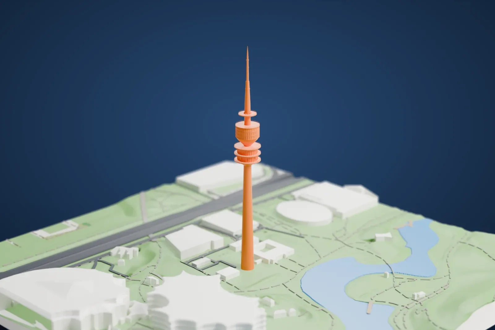 A white 3D print of the Olympiaturm, a tall slender tower with round platforms and a needle spire, standing in a park beside lakes and large roofed buildings.