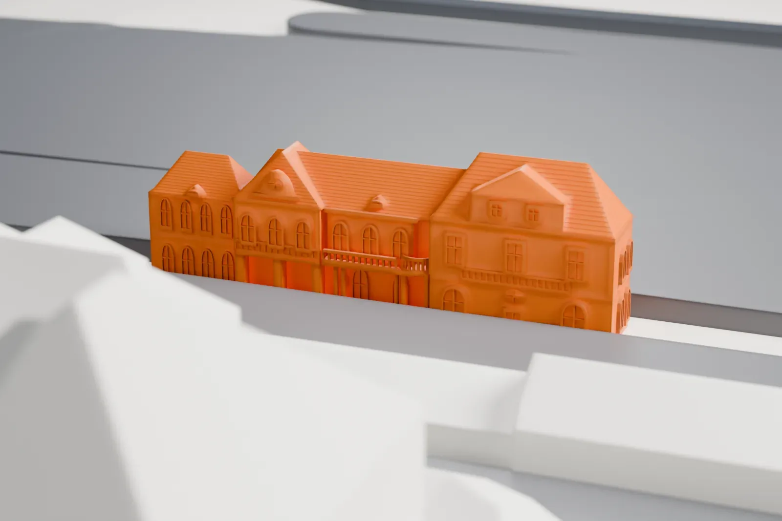A white 3D print of Oranienburg station, a railway station building among surrounding streets and buildings.