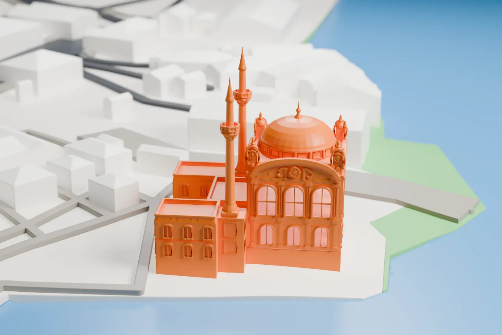 A white 3D print of the Ortaköy Mosque, a small domed mosque with two slender minarets, on a square beside the water with the surrounding city of Beşiktaş around it.
